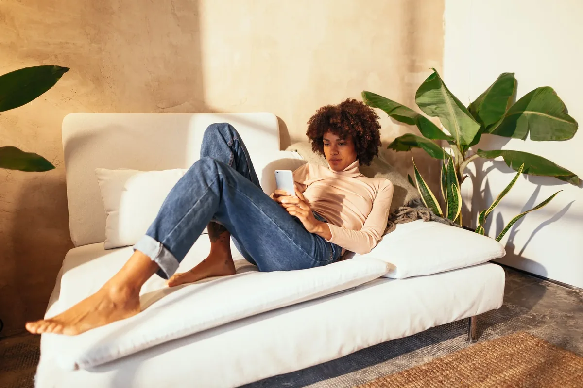 A client relaxed on a couch, talking on the phone